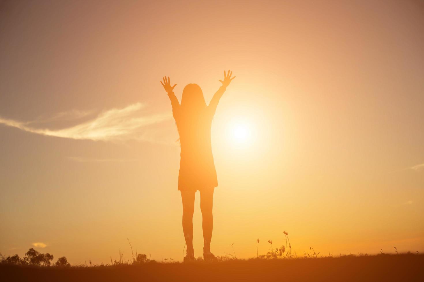 Silhouette of woman praying over beautiful sky background photo