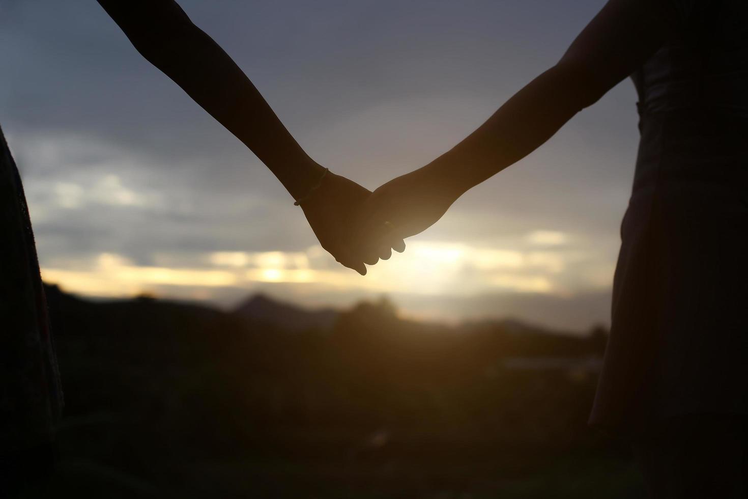 young couple holding hands. In Nature sunrise photo