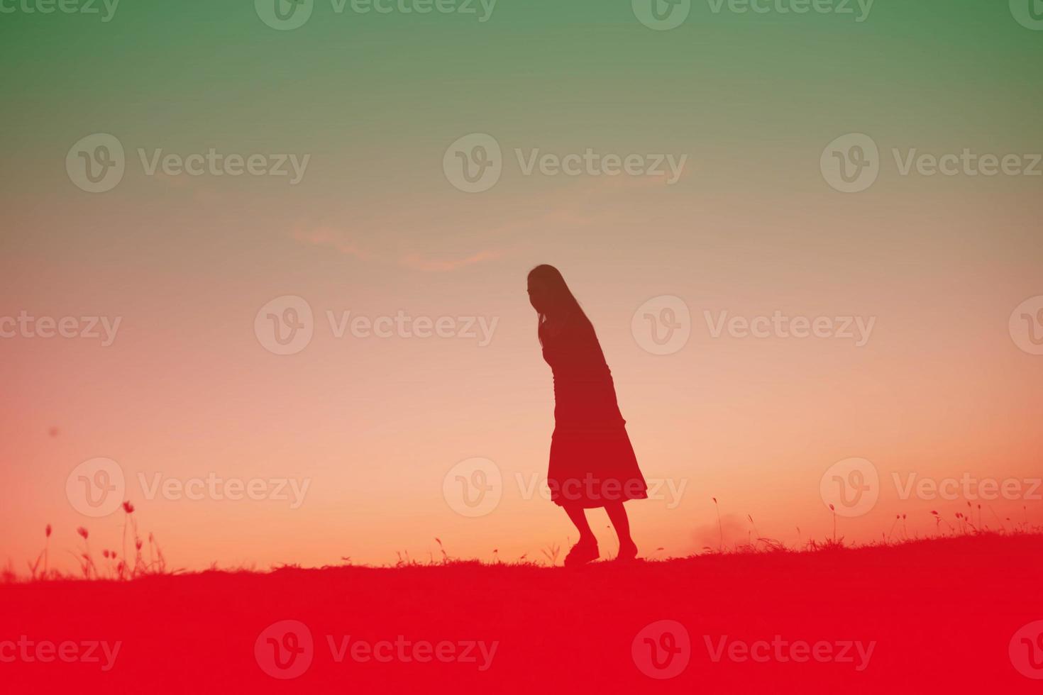 silhouette of a young woman standing alone photo