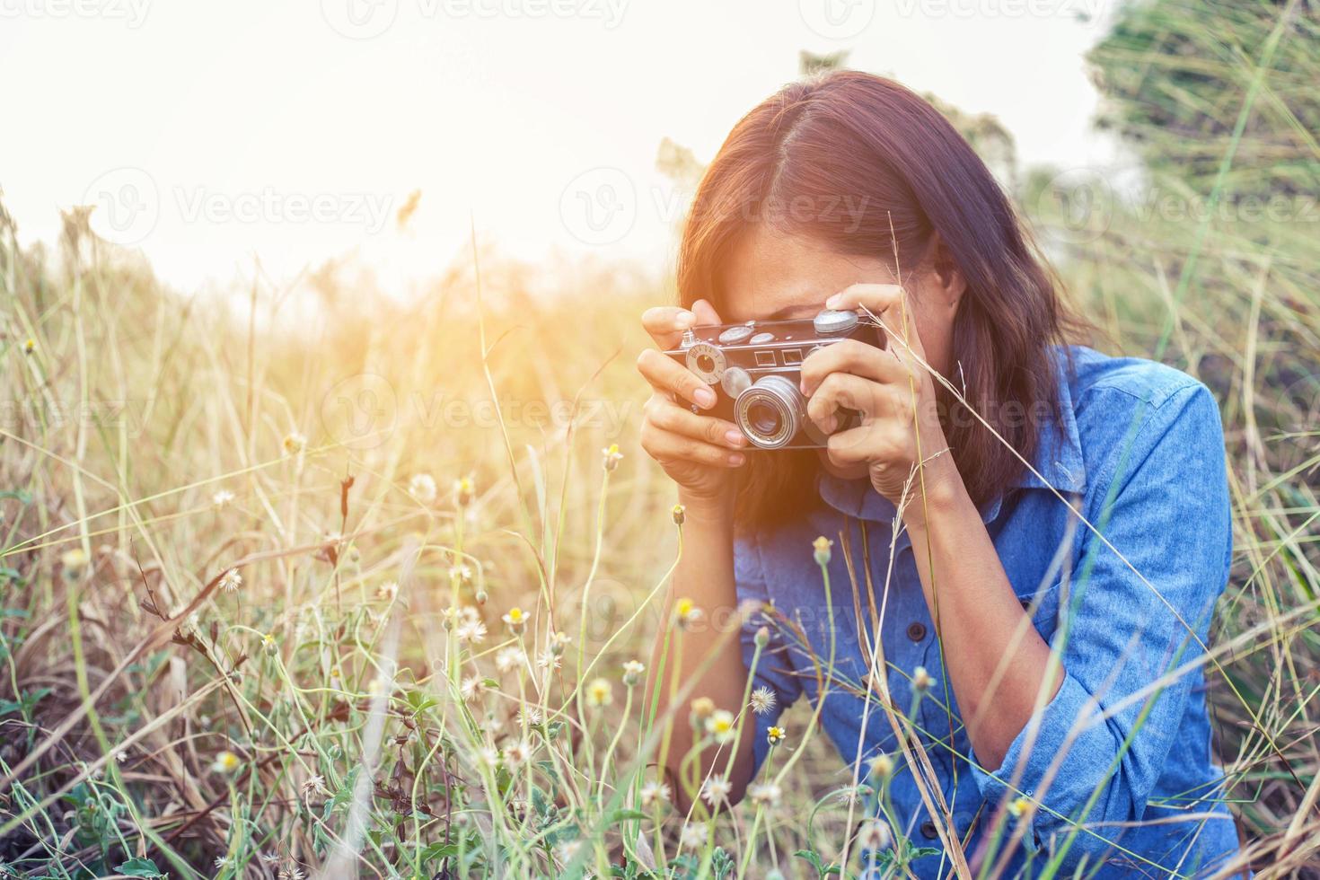 vintage de fotografía de mujeres hermosas mano de pie sosteniendo cámara retro con amanecer, estilo suave de ensueño foto