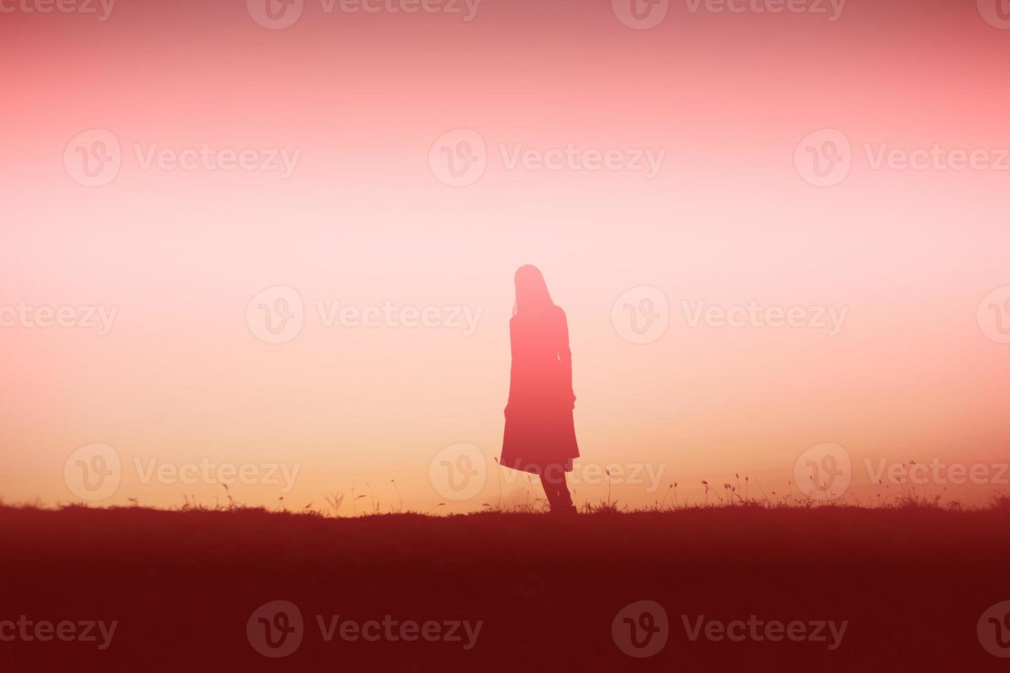 silhouette of a young woman standing alone photo