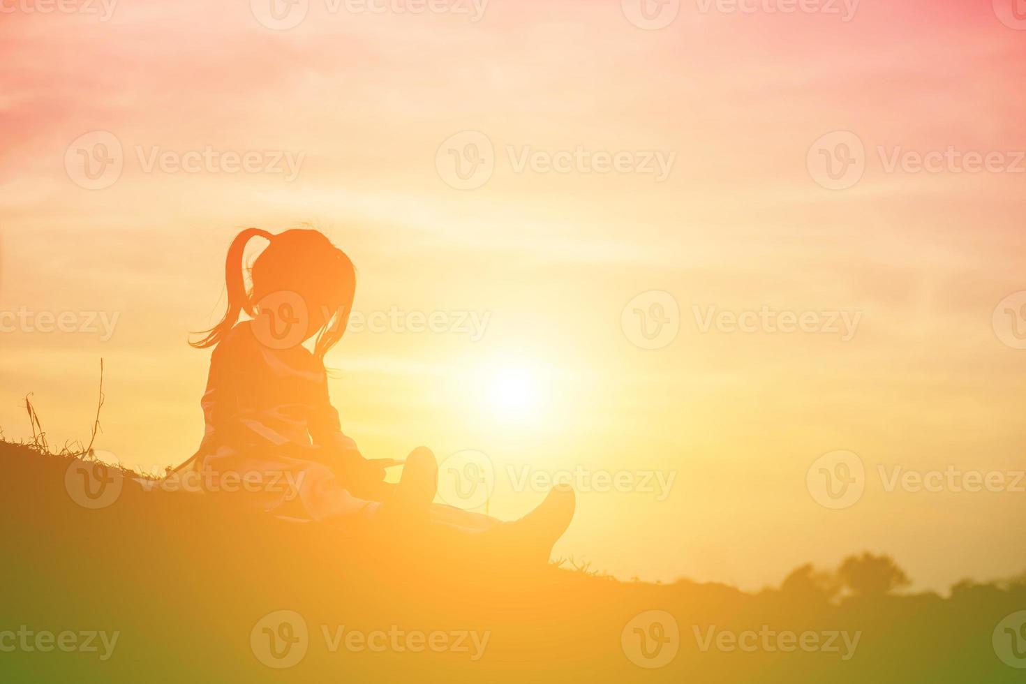 silueta de niño, momentos de alegría del niño. en la puesta de sol de la naturaleza foto