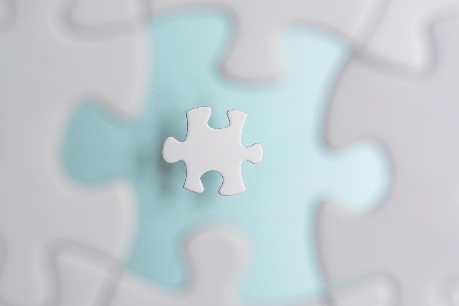 Puzzle pieces isolated on blurred blue background. Flat lay. Directly above. photo