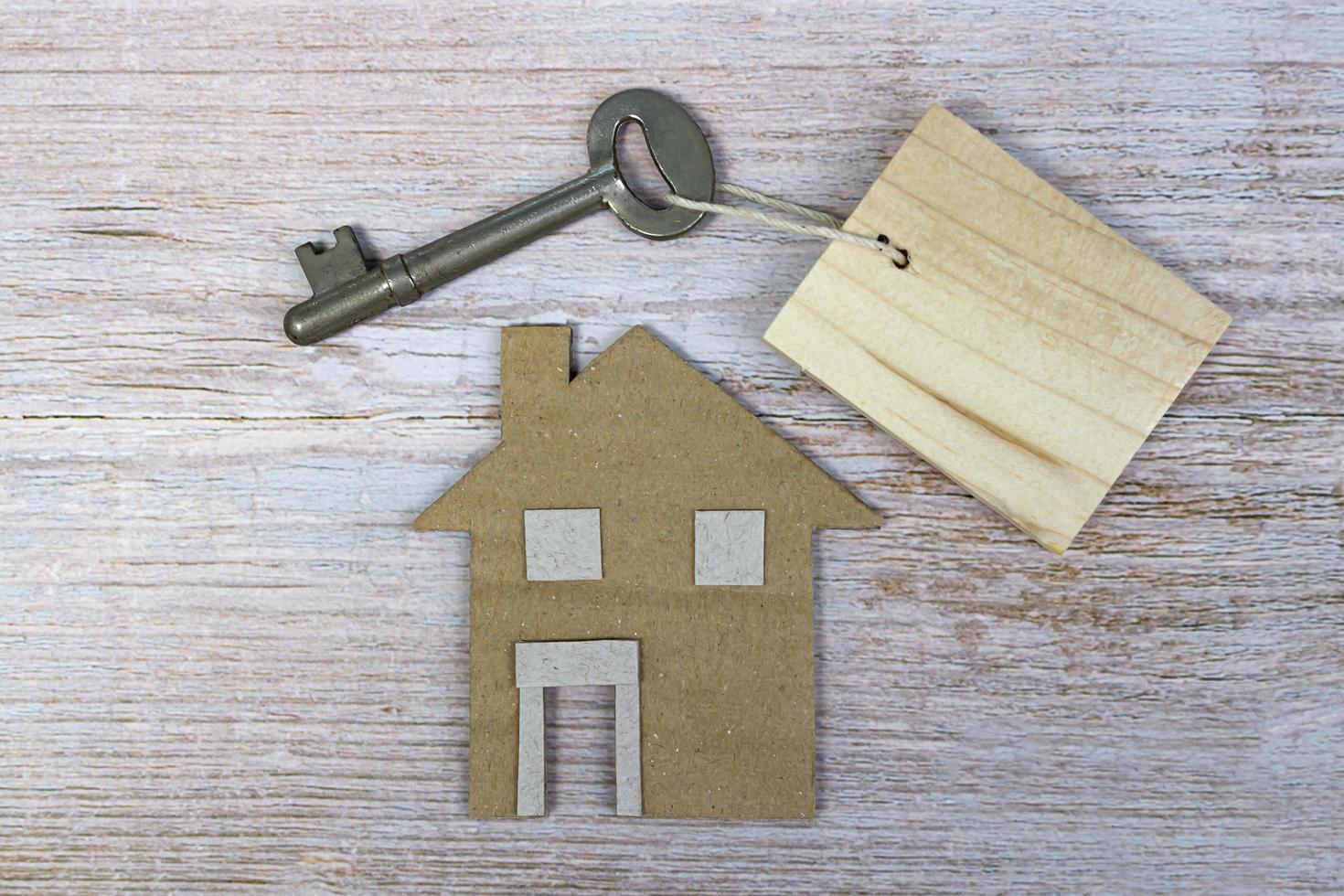 House model and key on wooden desk. Directly above. Flat lay. photo