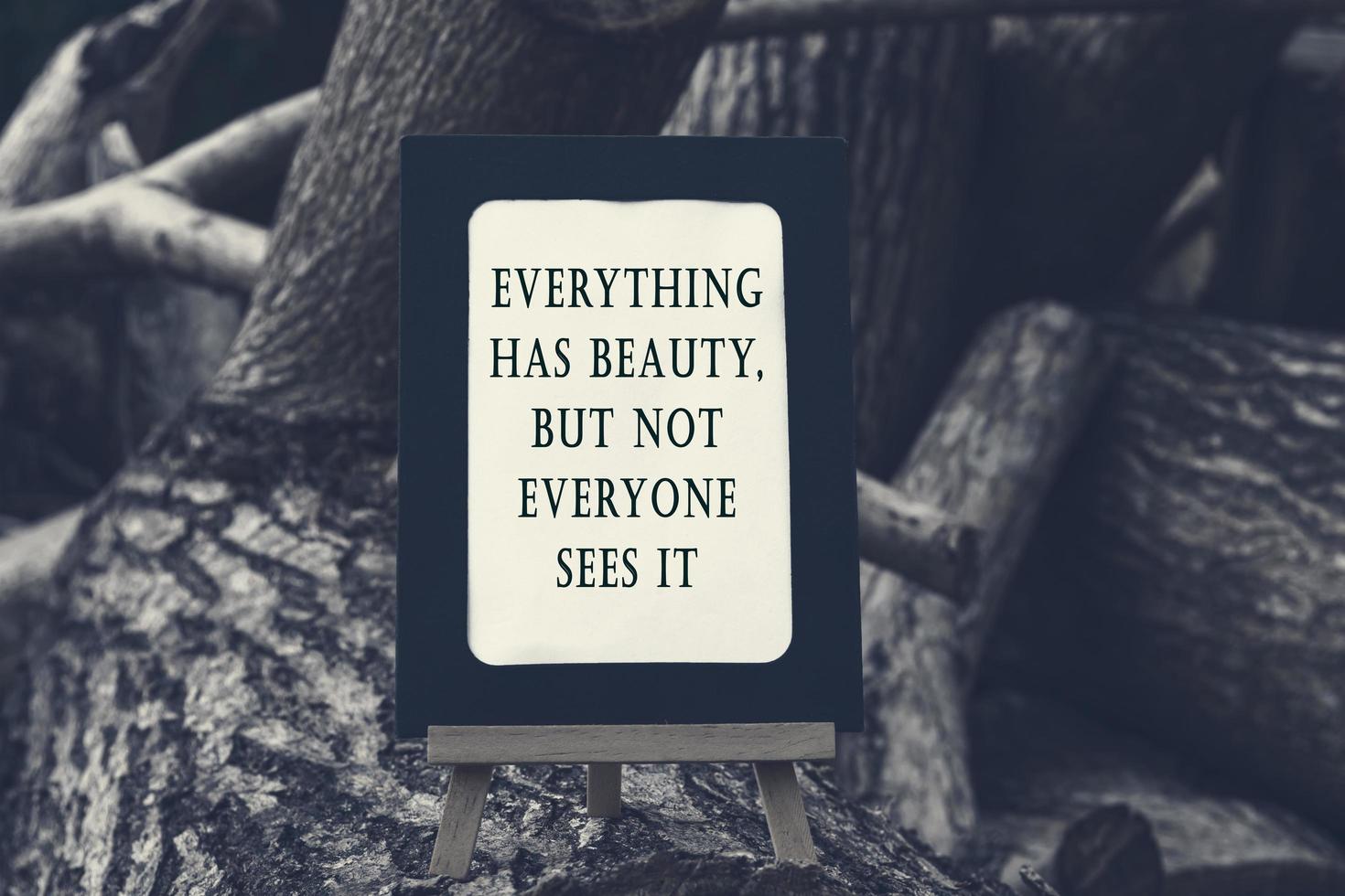 Motivational and inspirational quote on a chalkboard isolated on tree trunk. photo