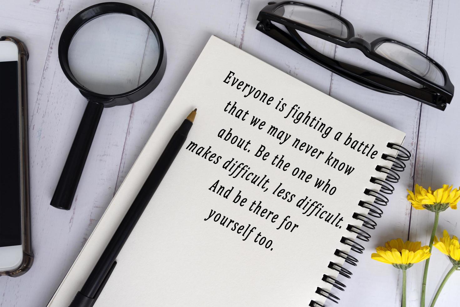 Motivational and inspirational quote on black note book on wooden desk. photo