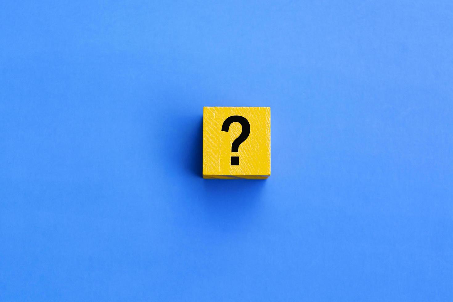 Cube with question mark on blue background. photo