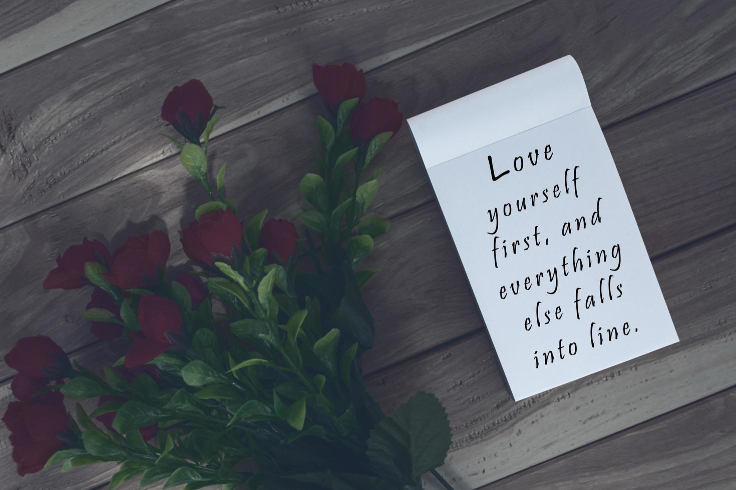Motivational and inspirational quote written on a notepad on wooden background. photo