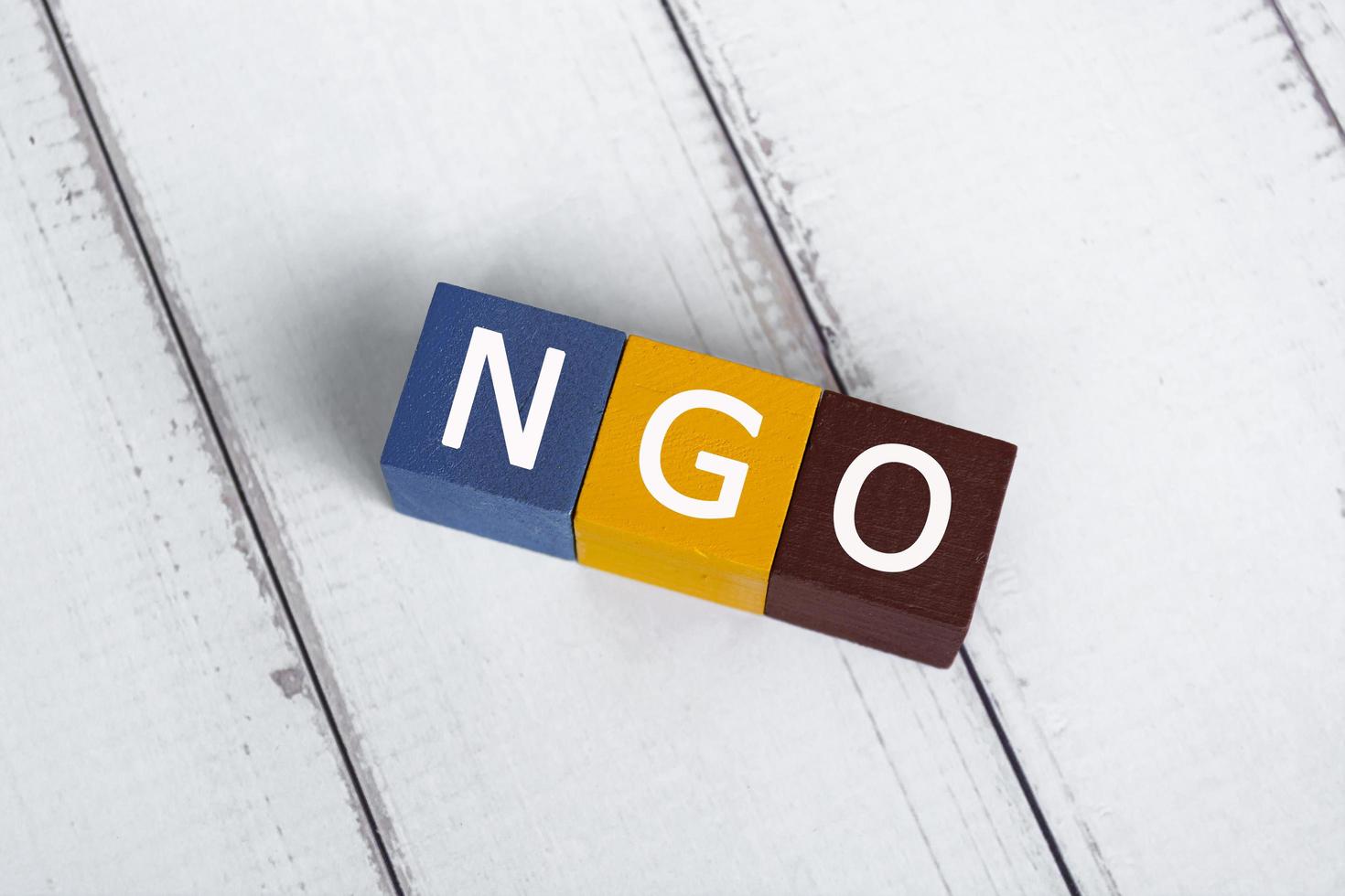 NGO acronym for Non-Governmental Organization on colorful wooden cube. photo
