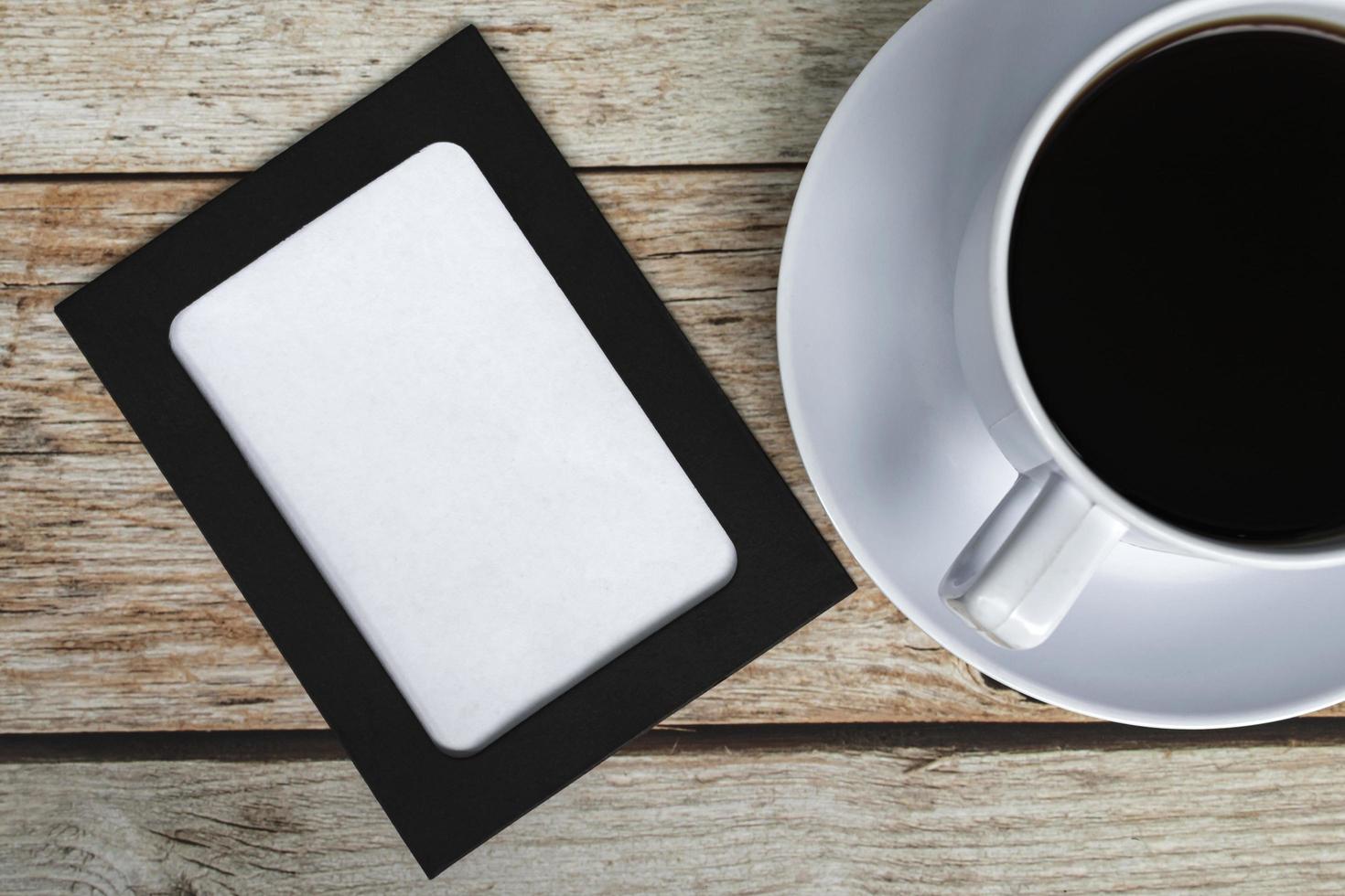 Directly above view of chalkboard with coffee cup on wooden desk. photo