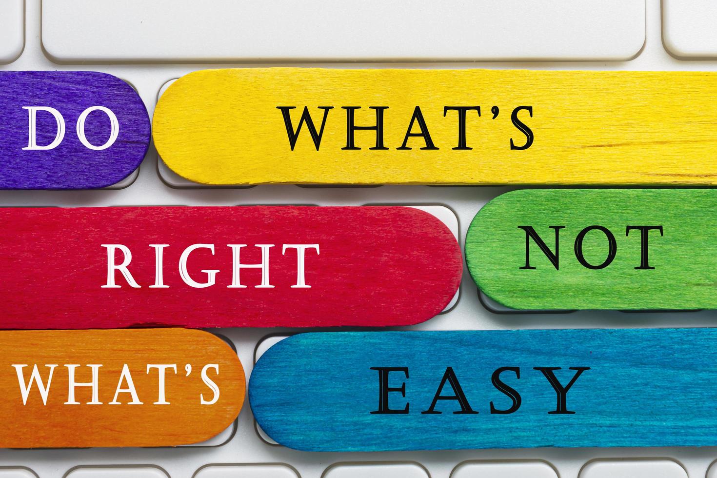 Colorful wooden sticks with word on a white keyboard. Motivational quote. photo