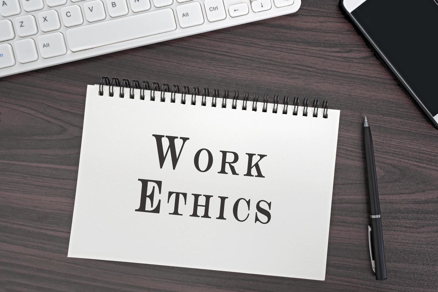 Top view and flat lay of office desk and notepad with Work Ethics word. photo