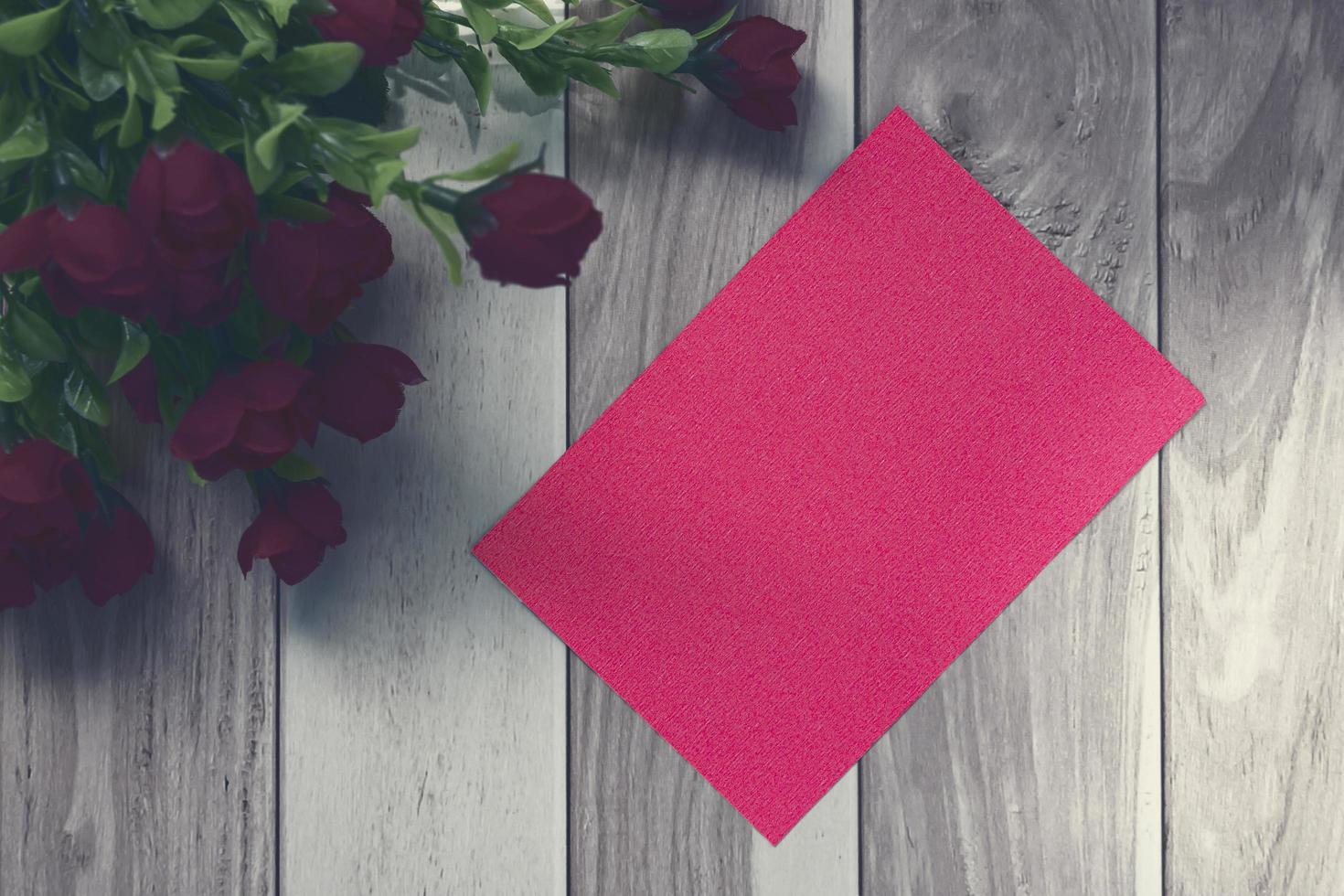 Red note on wooden surface and red roses bouquet flat lay with copy space photo