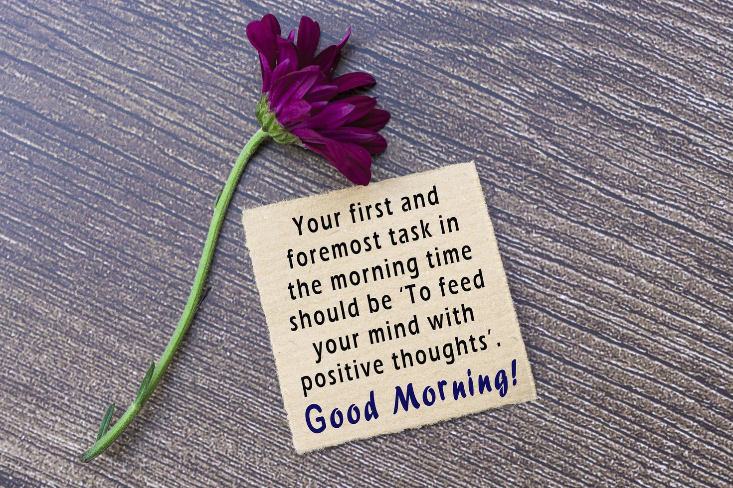 Motivational on brown note on wooden surface. Morning quote. photo