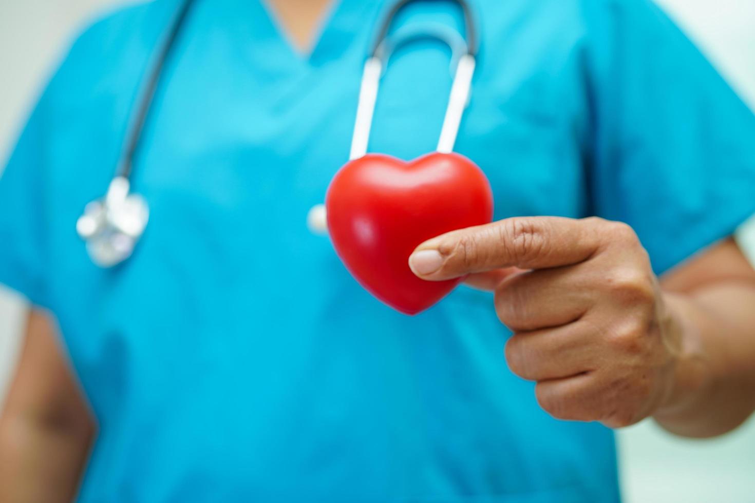 Asian woman doctor holding red heart for health in hospital. photo