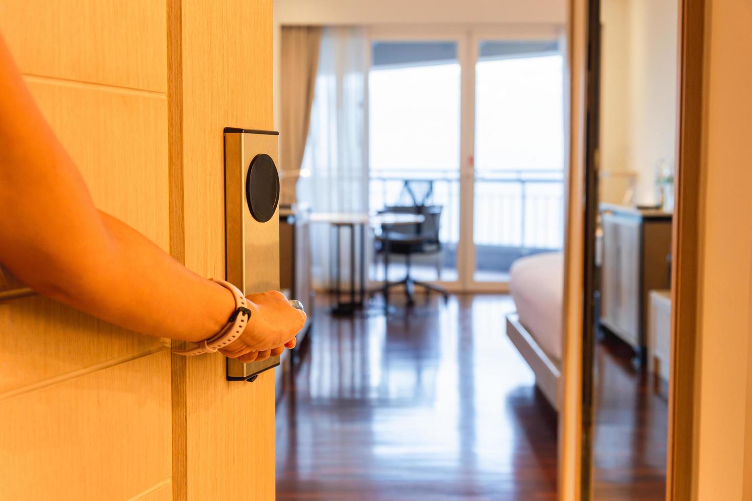 Half-open door of a hotel bedroom with hand photo