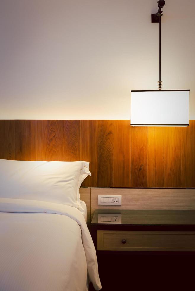Bedroom interior elements with stylish ceiling lamp on bedside table indoor. photo