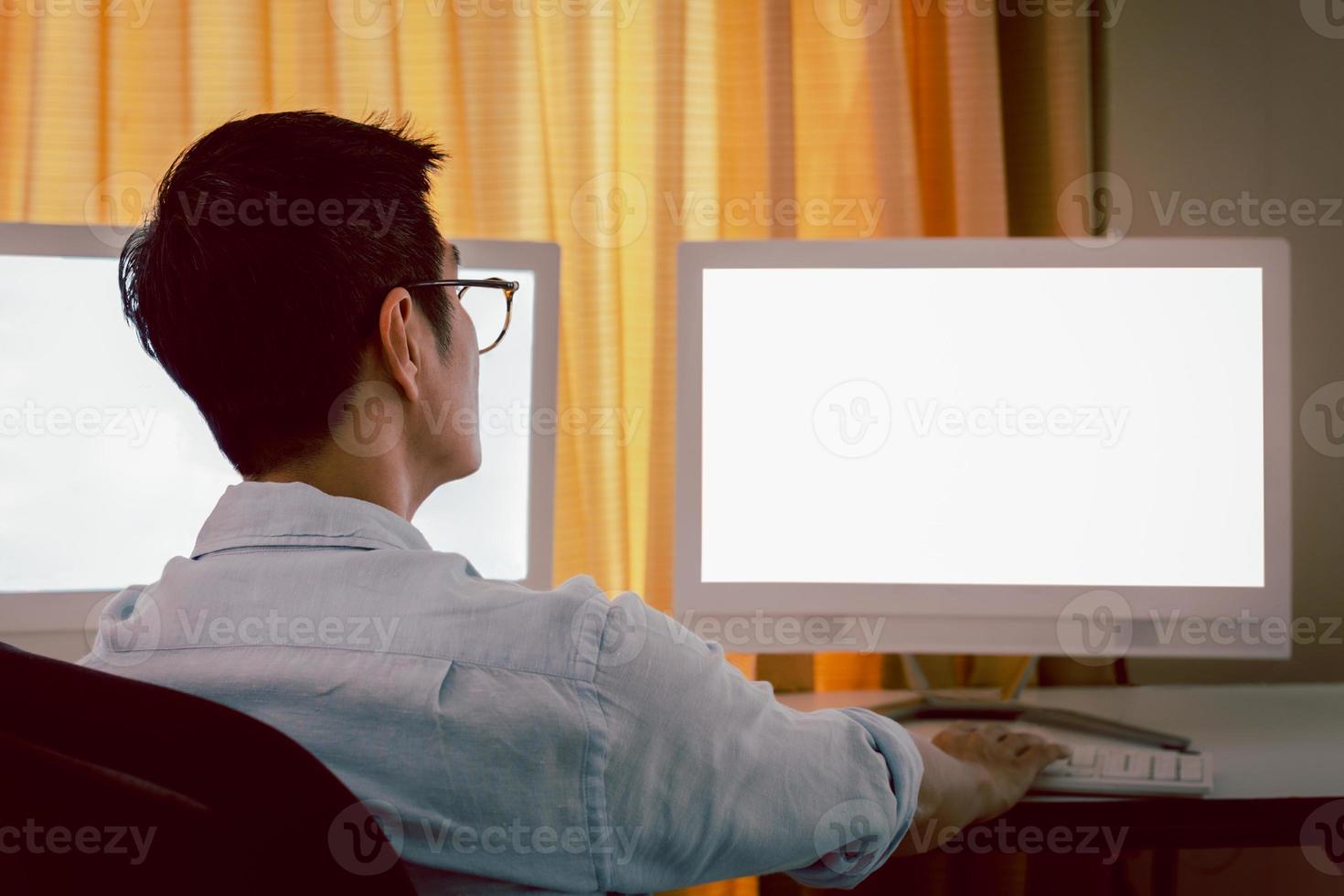 Businessman and eyeglasses working with charts and market reports on computer screens. photo