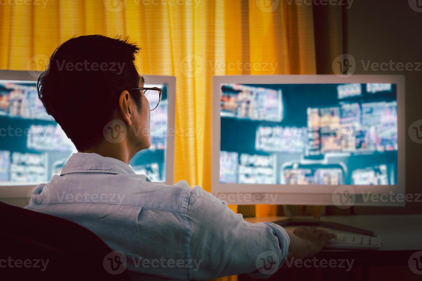 Businessman and eyeglasses working with charts and market reports on computer screens. photo