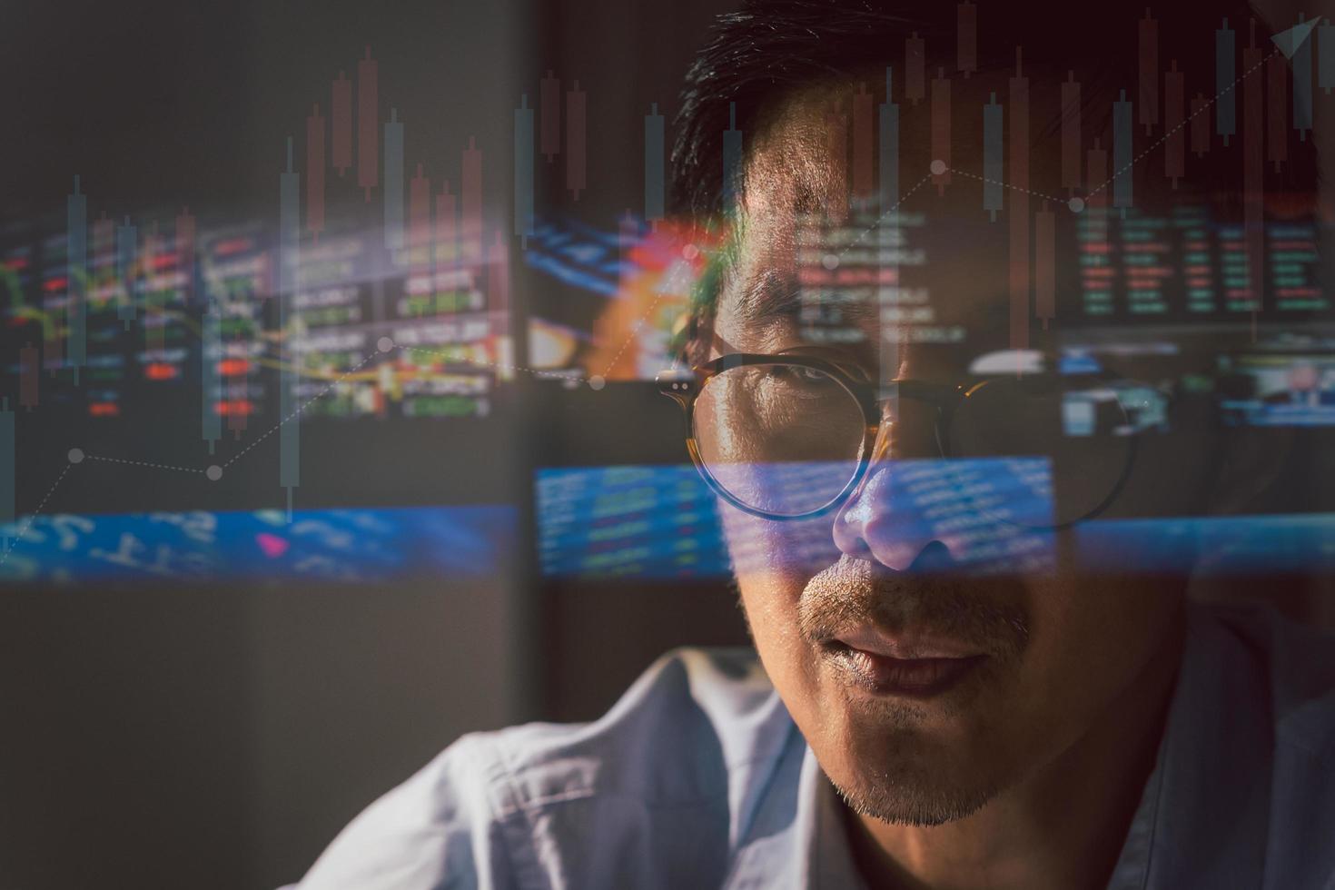 Close up trader working on laptop analyzing online stock market with reflection. photo
