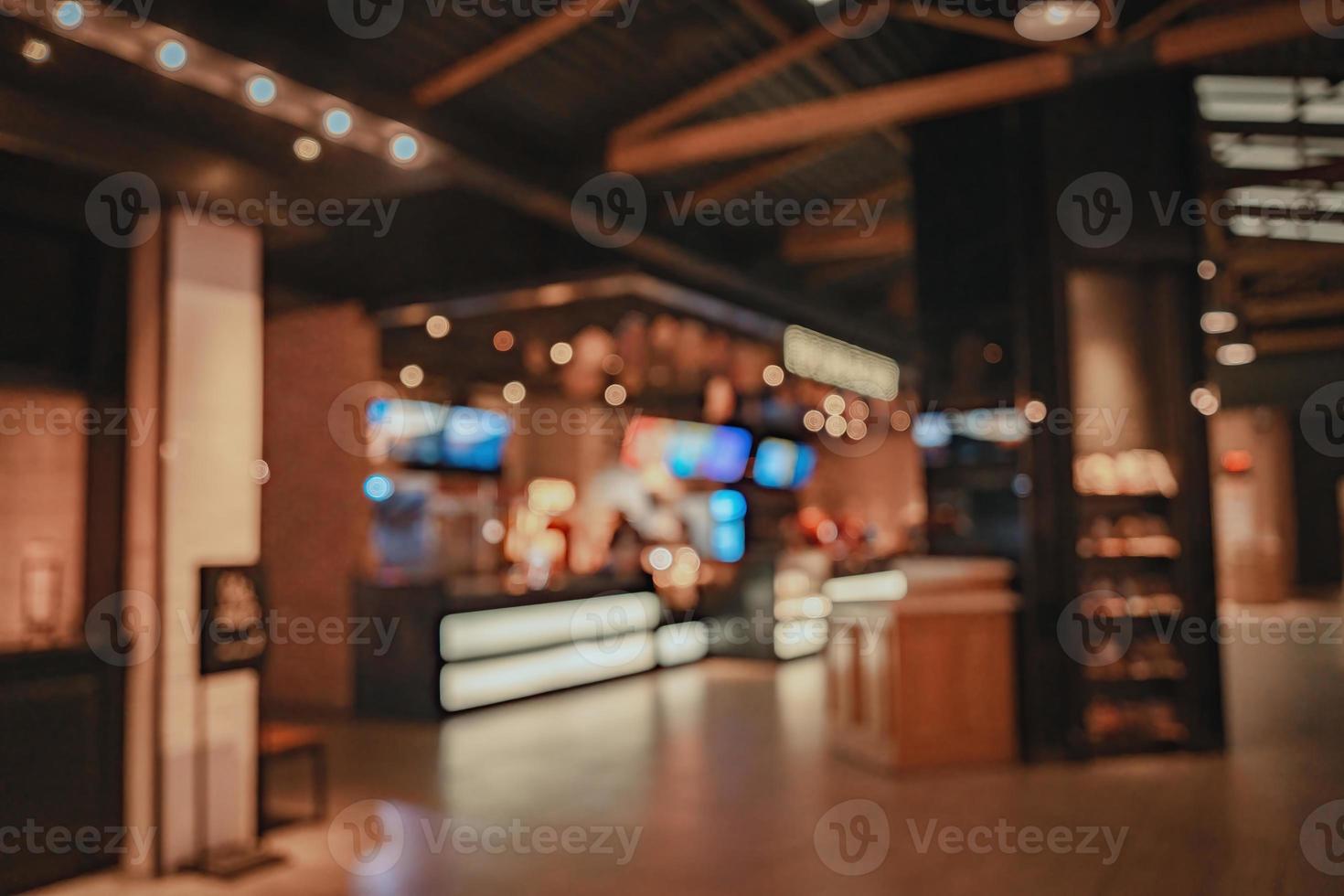 Movie theater entrance interior blur image use for background of business and cinema concept. Abstract blur people queuing to buy ticket at the counter and buy popcorn. photo