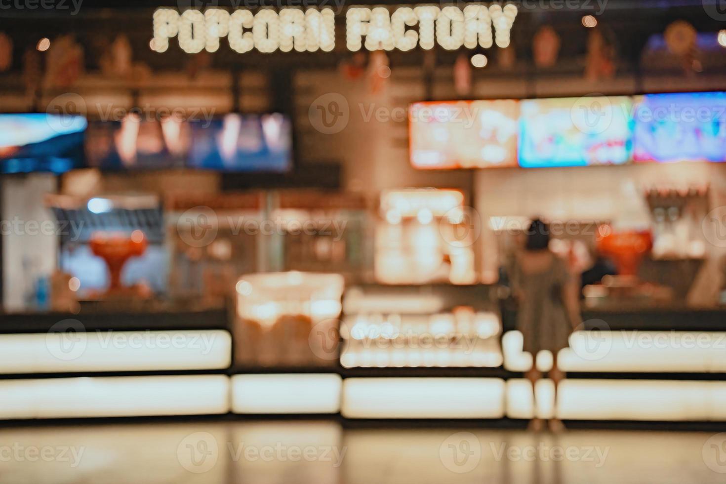 Movie theater entrance interior blur image use for background of business and cinema concept. Abstract blur people queuing to buy ticket at the counter and buy popcorn. photo