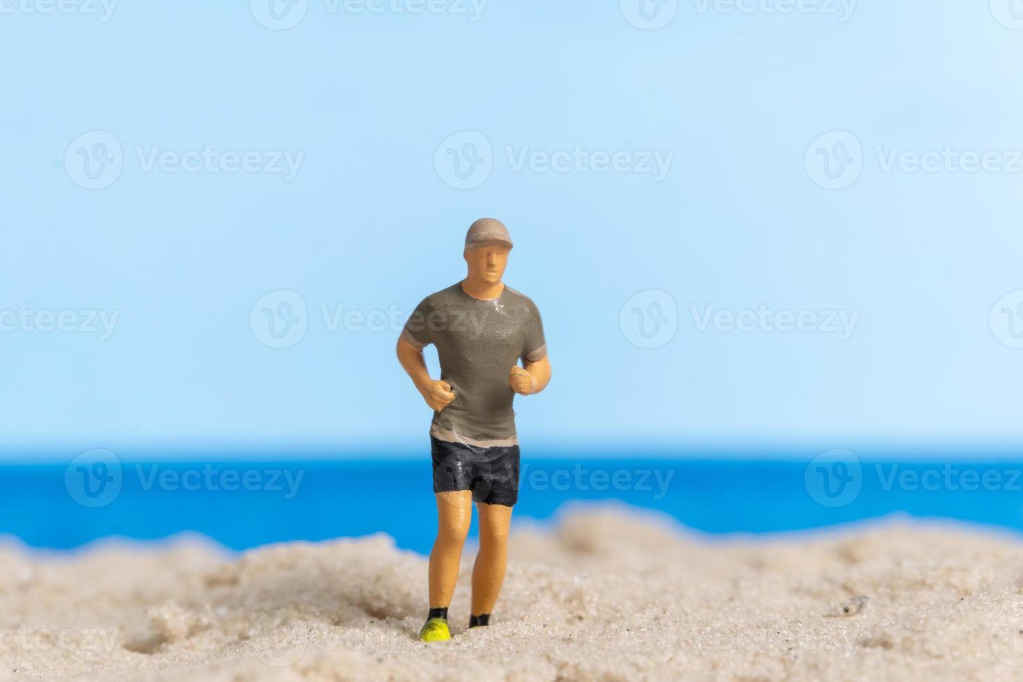 Miniature people running on The beach photo