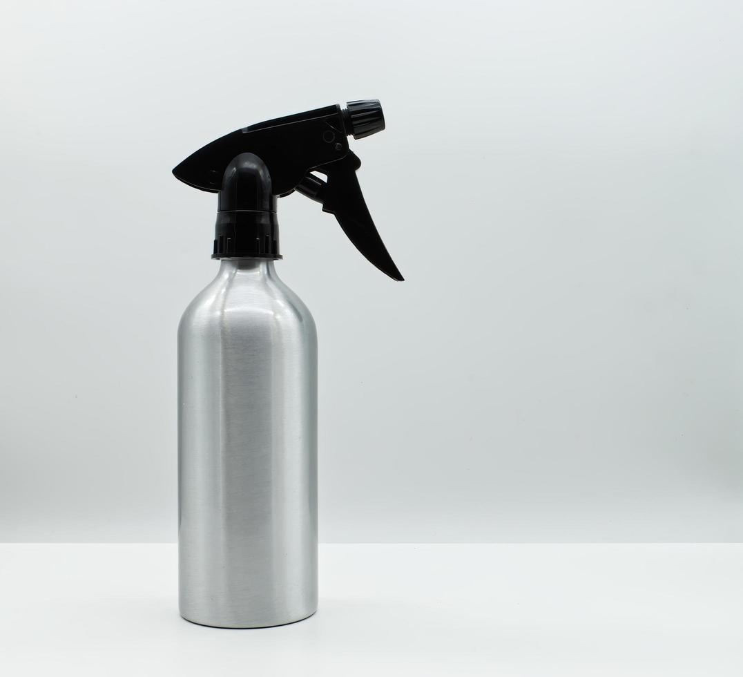 Silver spray bottle isolated on white background. Spry bottle without label for house cleaning. Cleaning service concept. photo