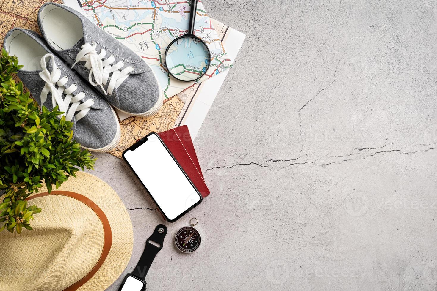 Top view travel accessories with shoes, map, smartphone with mockup screen, hat. Tourist essentials. photo