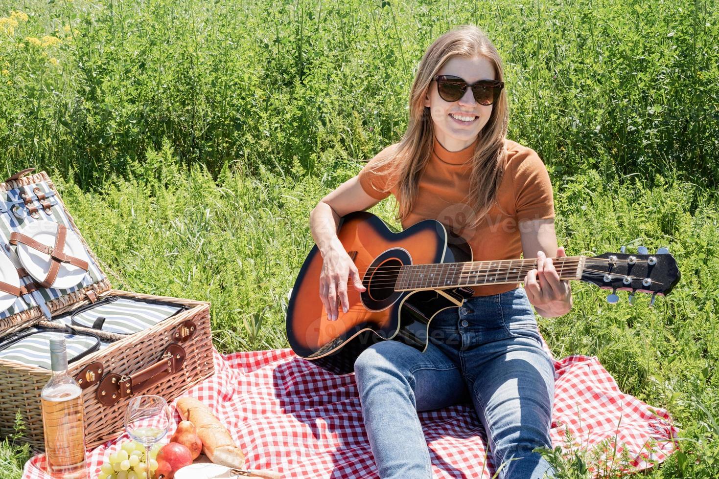 mujer joven tocando la guitarra en un picnic foto