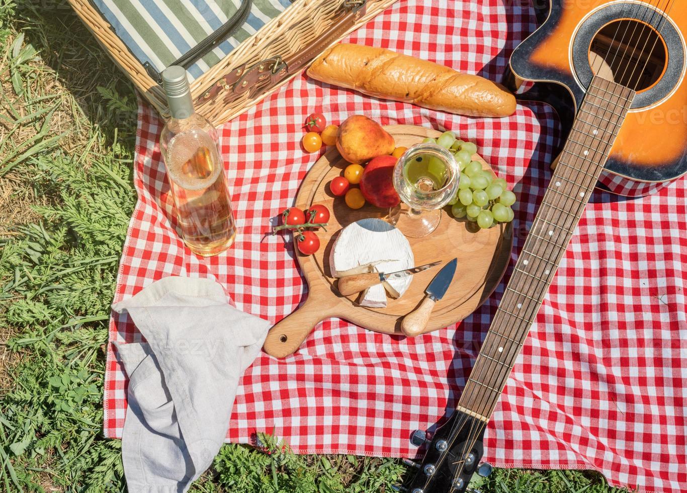 Closeup of picnic basket with drinks and food on the grass photo