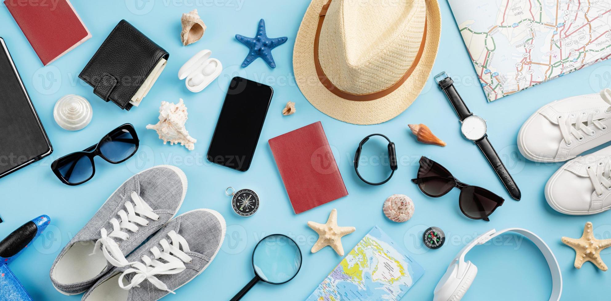 Top view travel accessories with shoes, map, smartphone with mockup screen, hat. Tourist essentials. photo