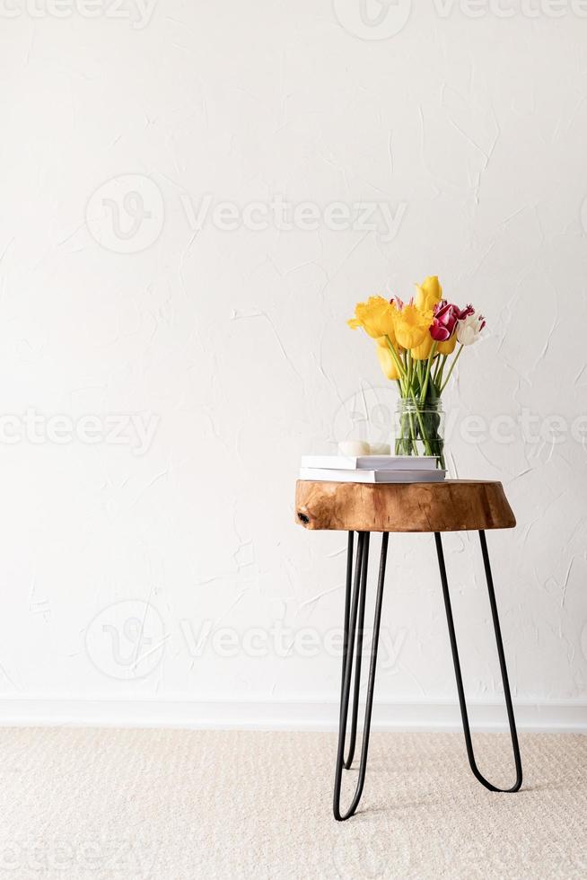 minimal home interior with stylish wooden coffee table and bouquet of fresh tulips photo