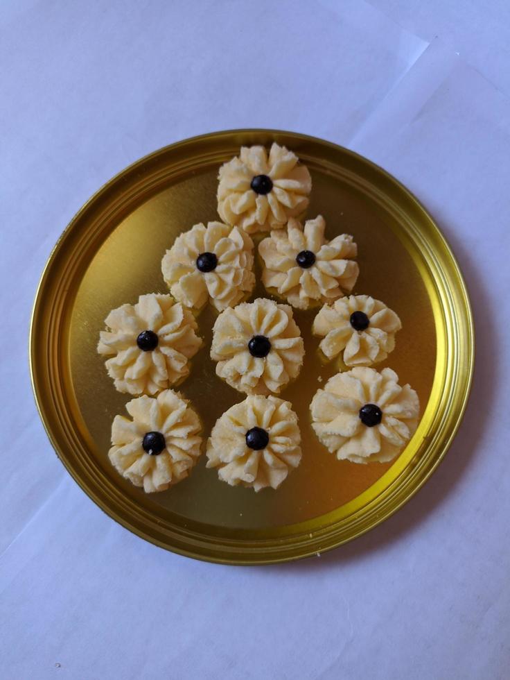 Flower shaped cookies with choco chips in the middle on golden plate photo