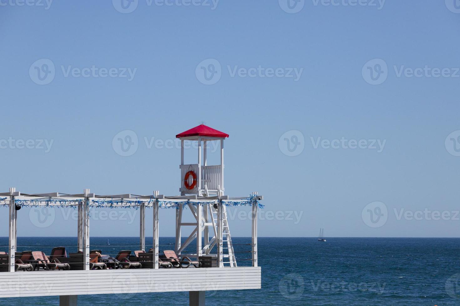 Rescue post, rescue tower on the beach against the backdrop of the sea and sky. photo