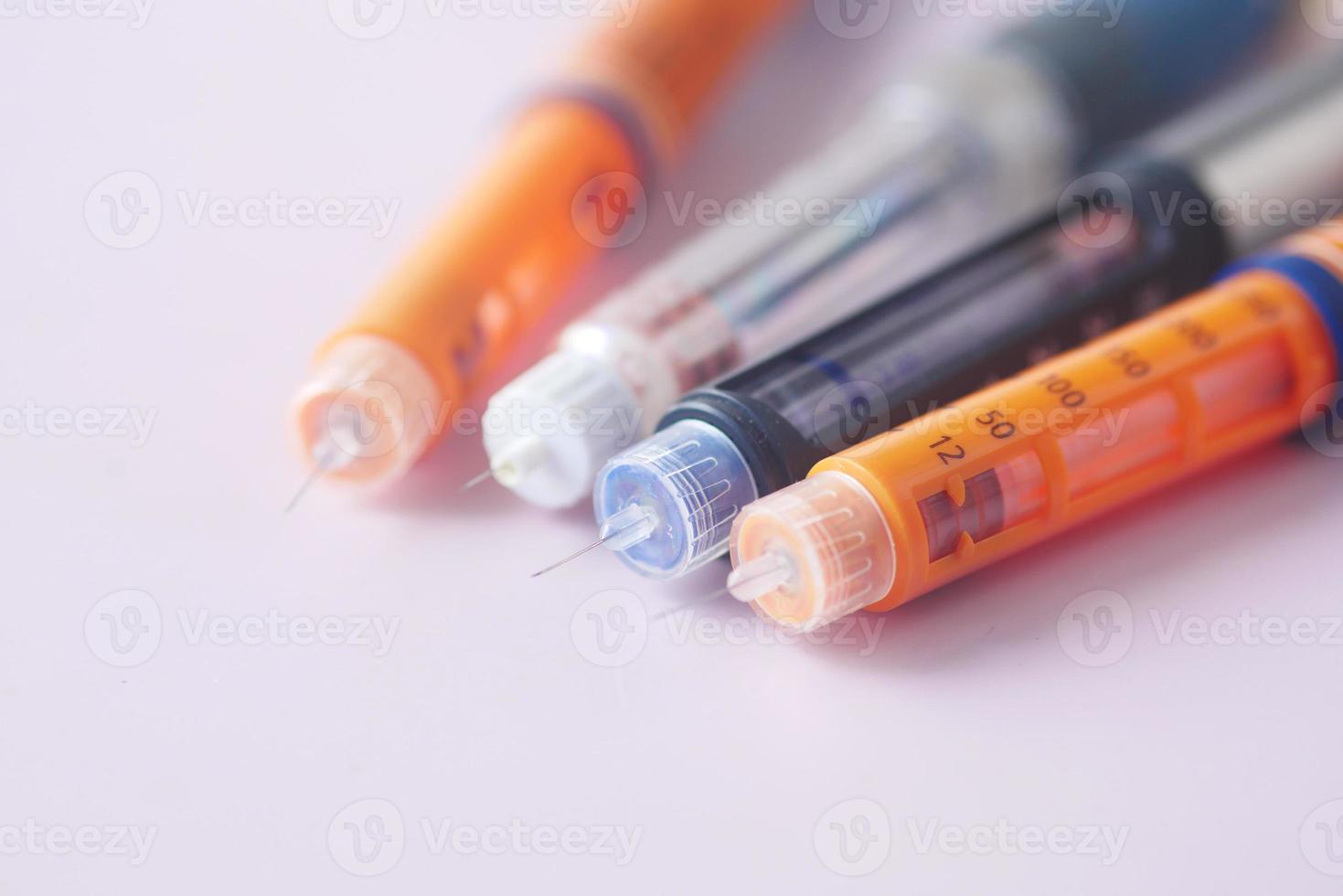 Insulin pens on color background, close up photo
