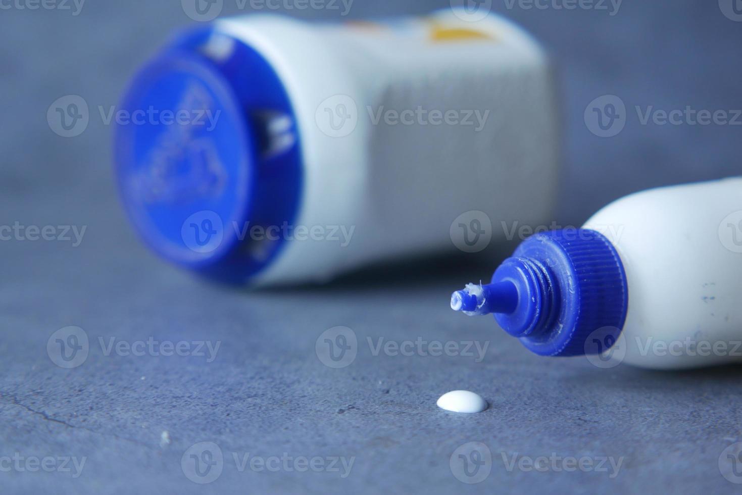 Glue Bottle Spilling on a black background . photo