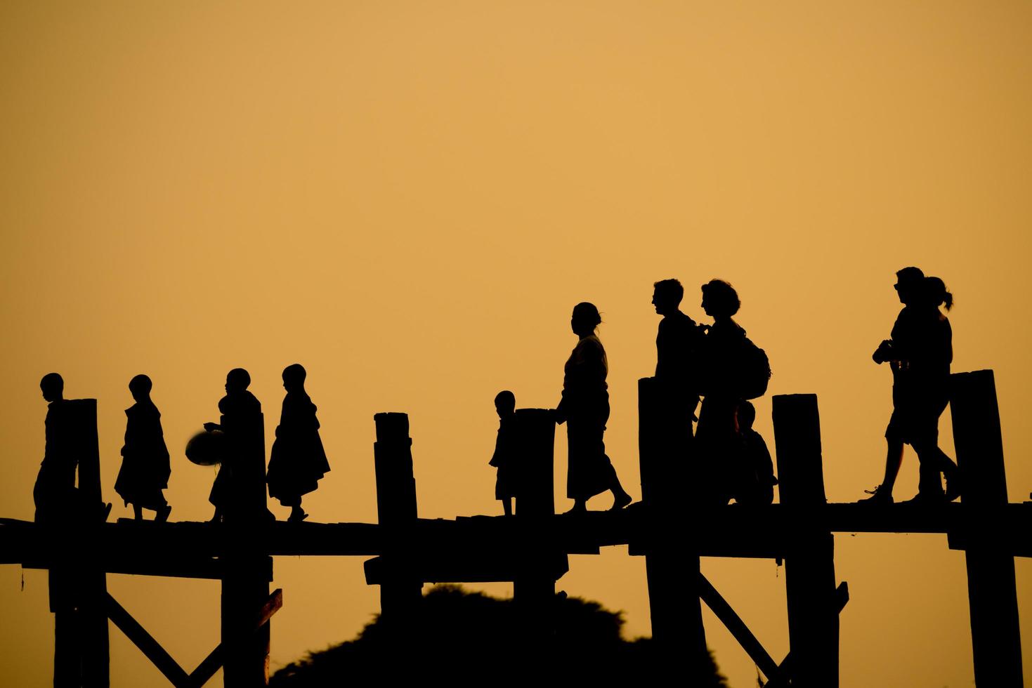 Silhouette of people walking on U Bein bridge in Amarapura, Myanmar. photo