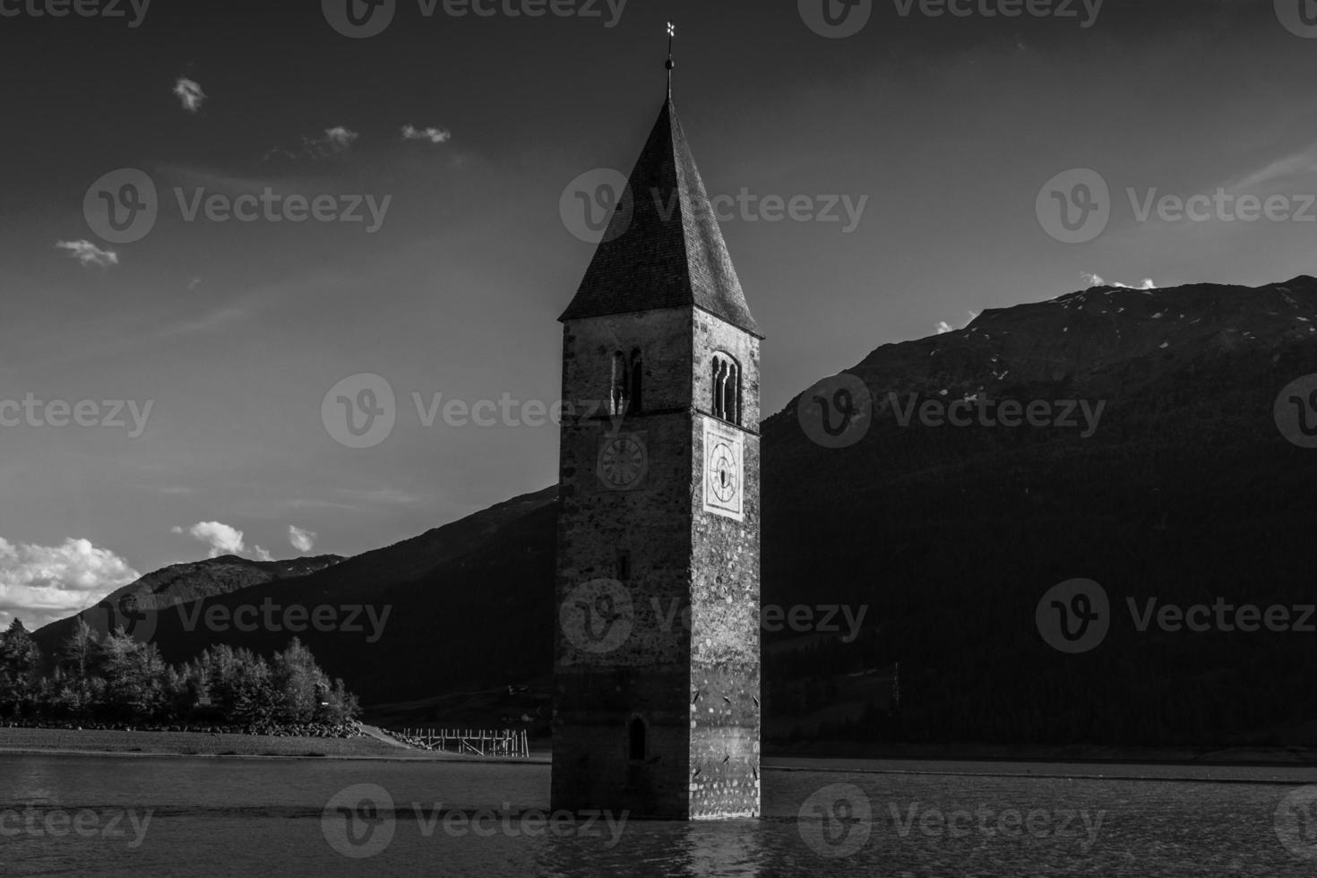 campanario sumergido de curon venosta en italia tirol del sur, antiguo edificio de un antiguo pueblo tragado por el agua del lago resia foto