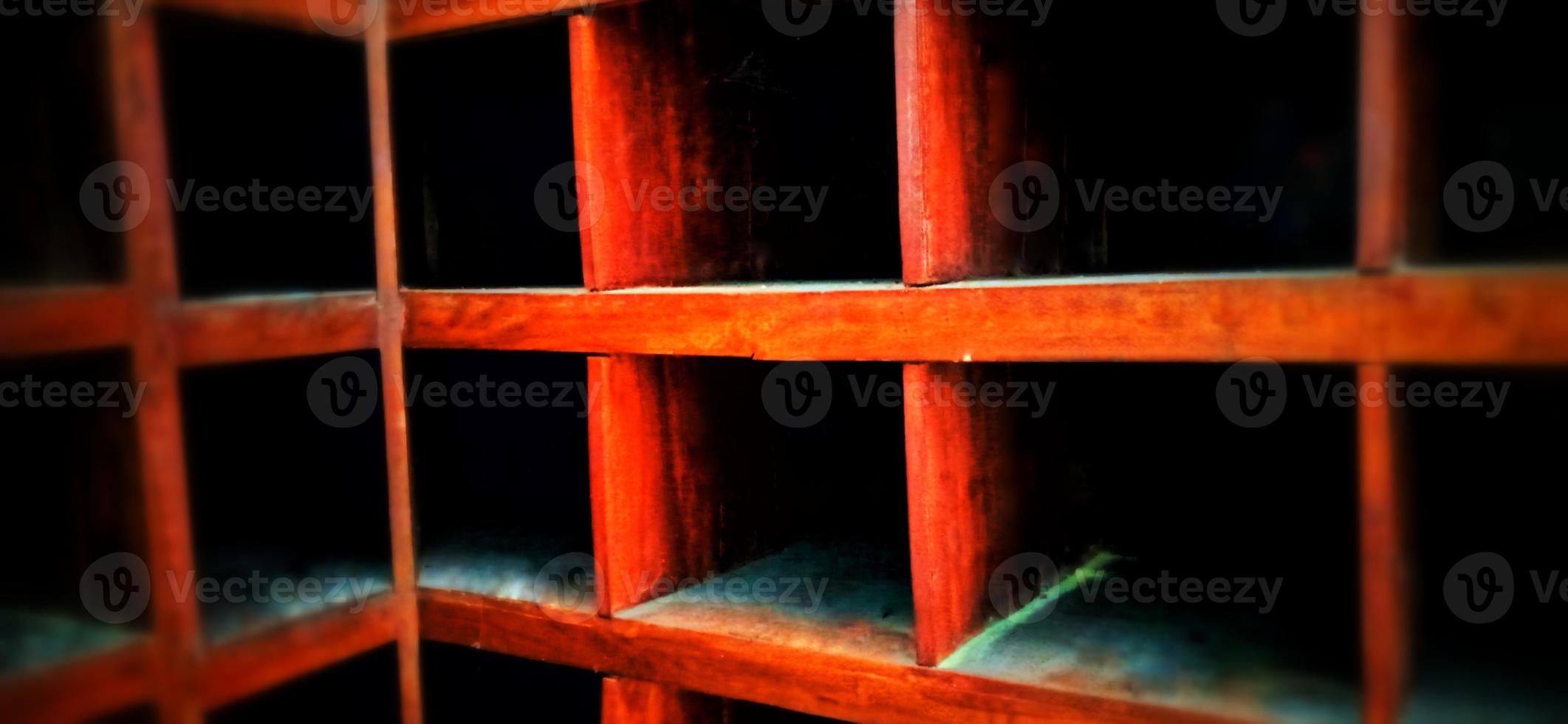 An old and dull red orange wooden locker under a dim background. photo