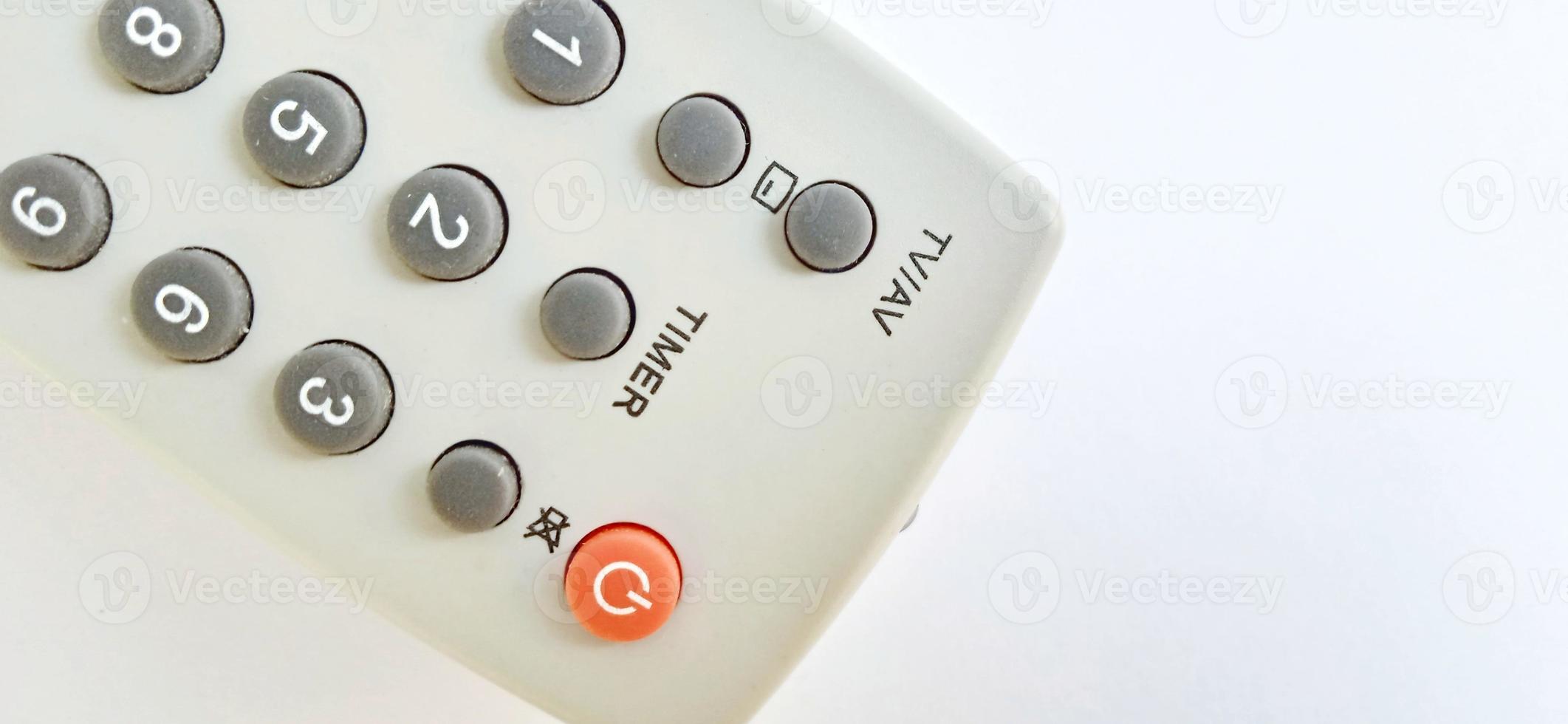 An isolated gray television remote control on the white gray background. Suitable for business, promotion, poster, backdrop, and advertising of company and industry. photo