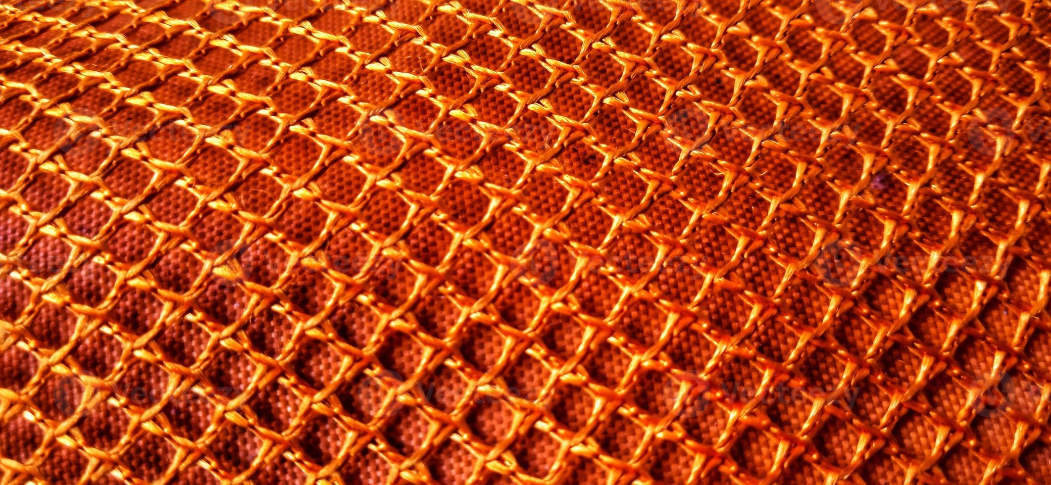 Gold orange honeycomb net patterns backgrpund. Synthetic honeycom net structure fabric background design. Available for text. Suitable for poster, backdrop, presentation, wallpaper, advertising, etc. photo