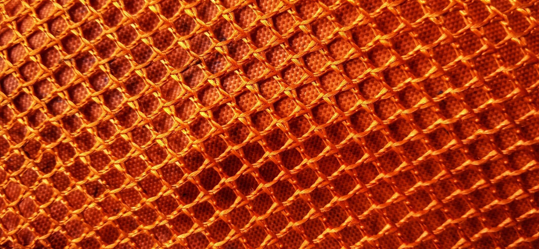 Gold orange honeycomb net patterns backgrpund. Synthetic honeycom net structure fabric background design. Available for text. Suitable for poster, backdrop, presentation, wallpaper, advertising, etc. photo