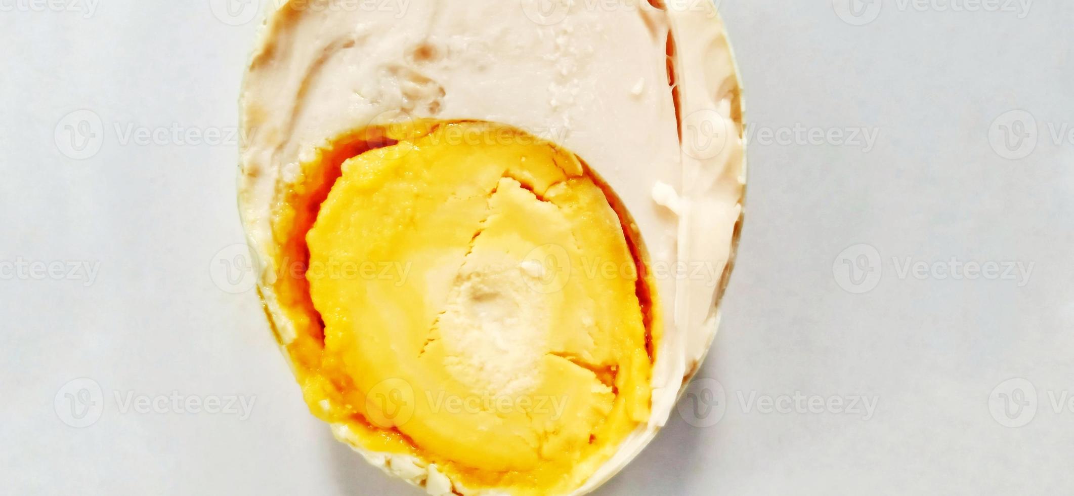 Indonesian food slice of salted egg or telur asin on the white gray plate background. Food ingredient background design. Suitable for advertising of food, drink, poster, backdrop, food company, etc. photo