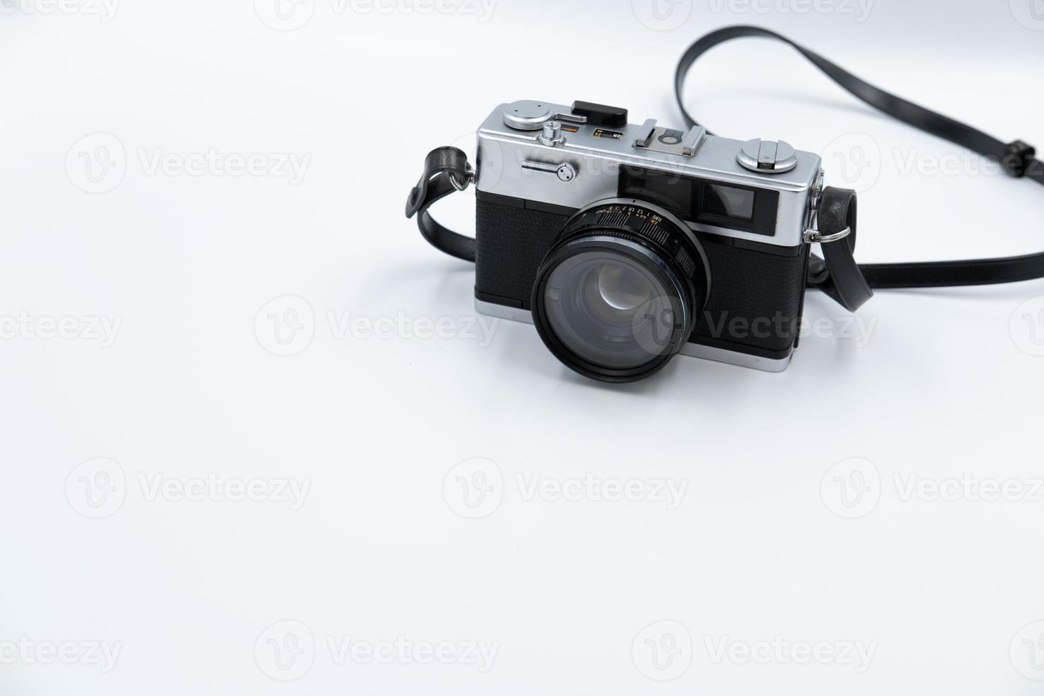 Isolated white background Beautiful vintage analog rangefinder film camera. 70's Decade film camera. Front left view image copy space. photo
