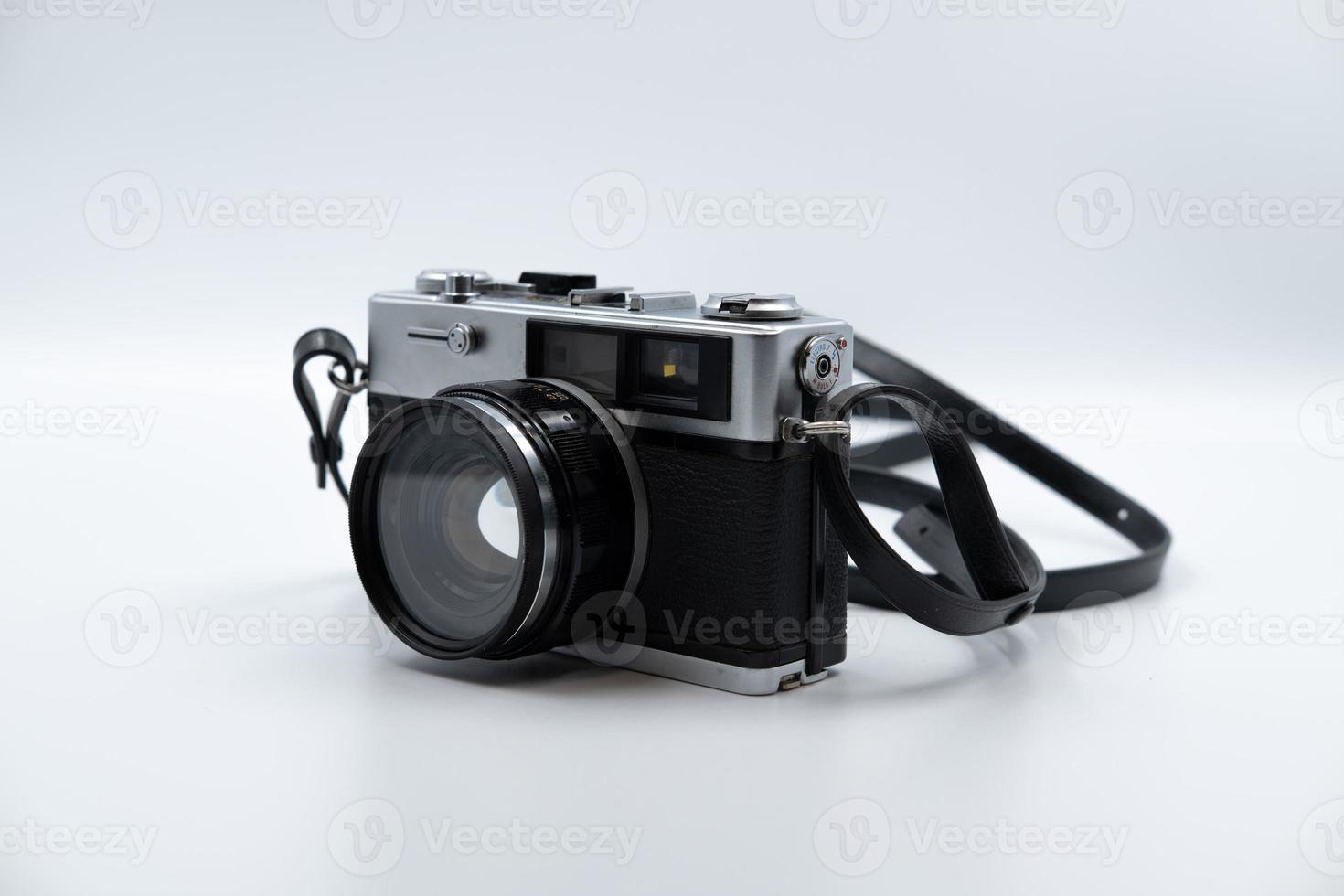 Isolated white background Beautiful vintage analog rangefinder film camera. 70's Decade film camera. Front left view image. photo
