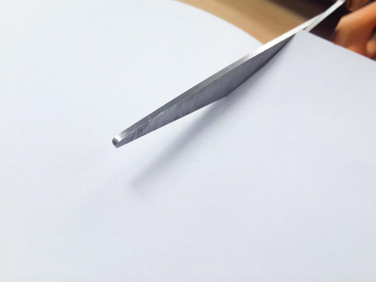 Scissors cutting the white paper, Copy space. photo