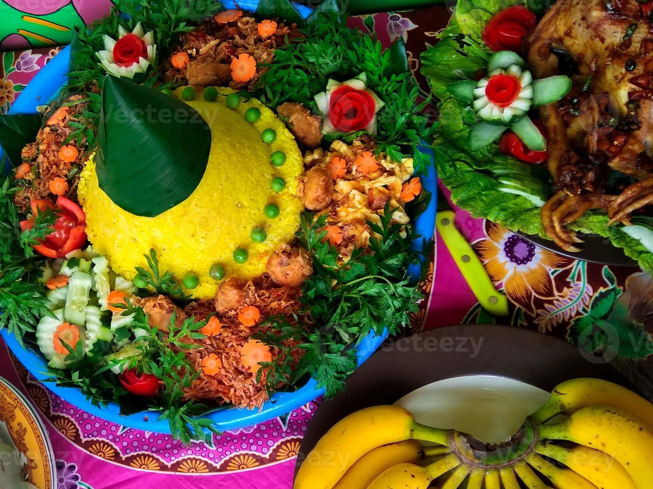 typical Indonesian tumpeng food, yellow rice with other complements photo