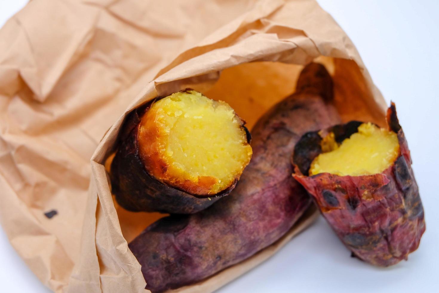 There are Roast sweet potatoes. Japanese Potato are on brown bag. White background. photo