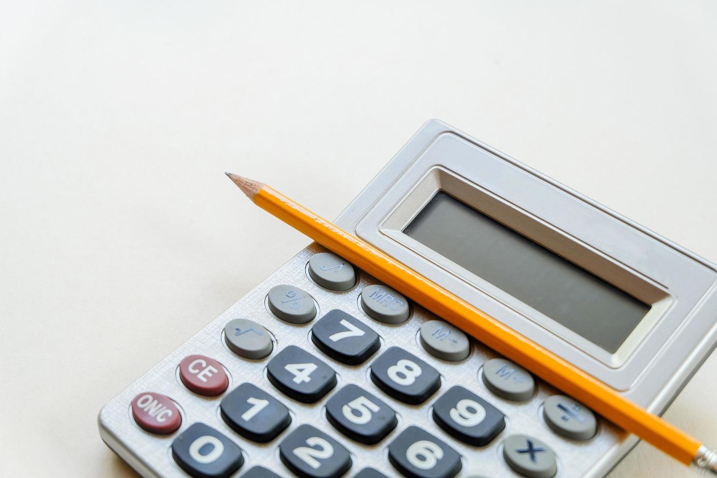 Close up and top view of Calculator with yellow pencil isolated on white background. Business finance or education concept. photo